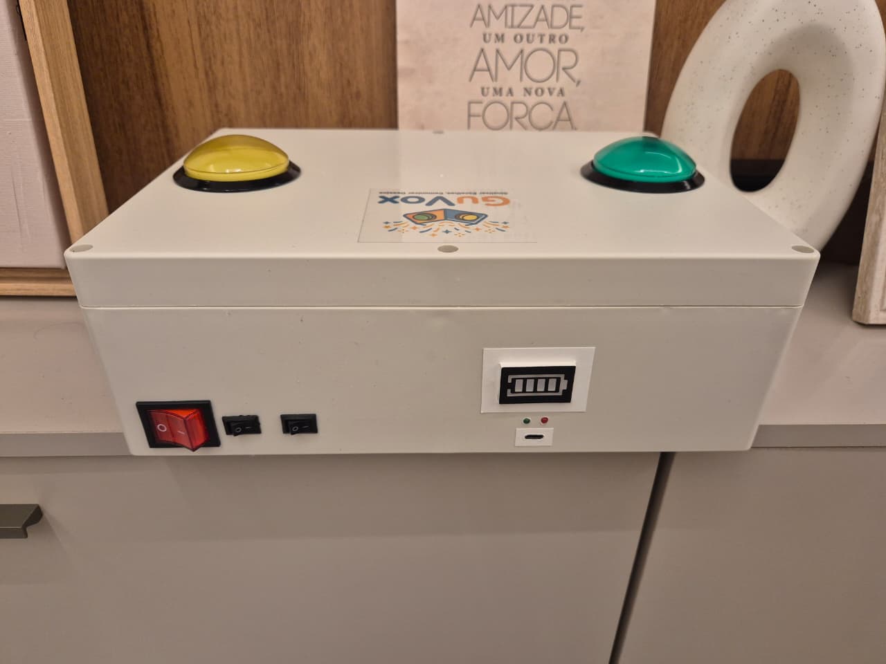 Visão lateral e traseira da caixa GuVox, mostrando a robustez da estrutura plástica e detalhes de acabamento.